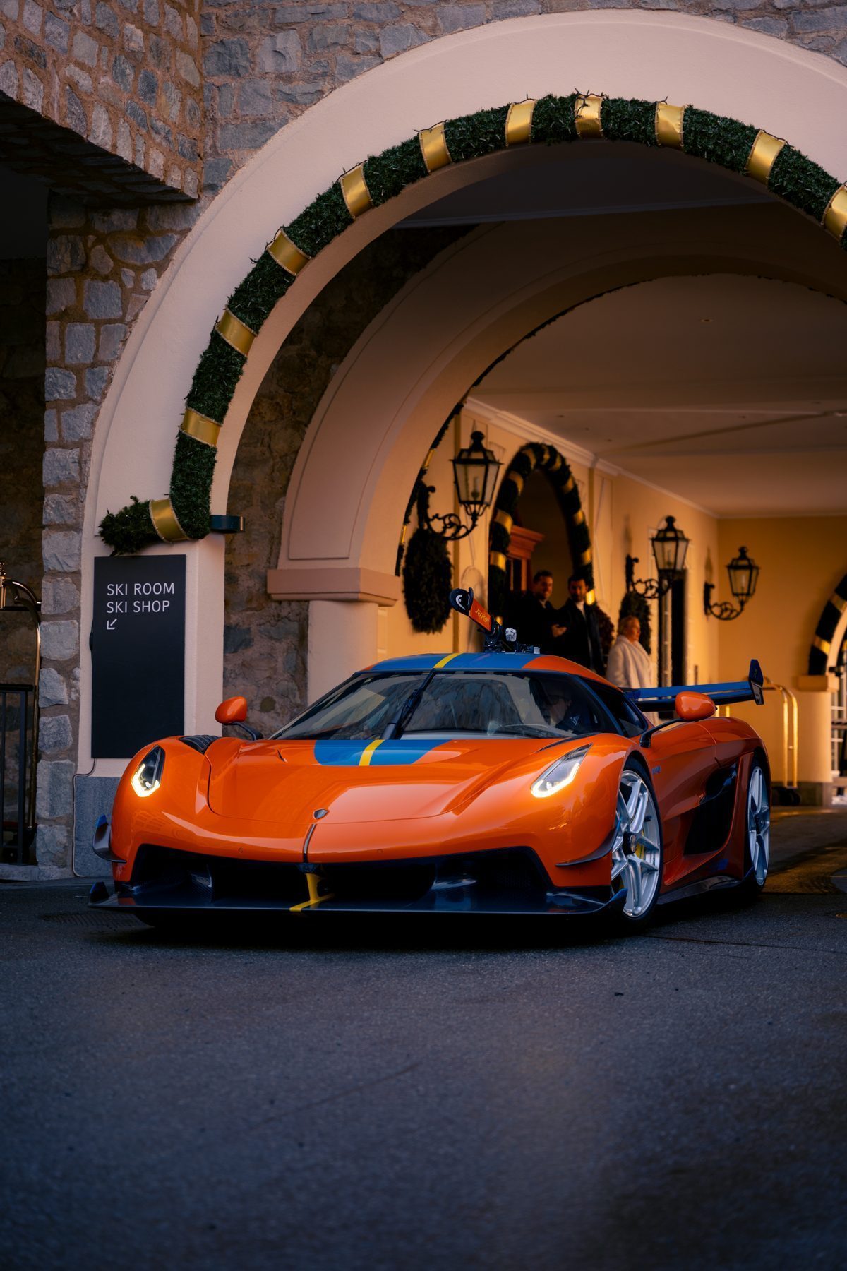 Koenigsegg-Hypercar unter einem Hotel-Bogen in der Abenddämmerung